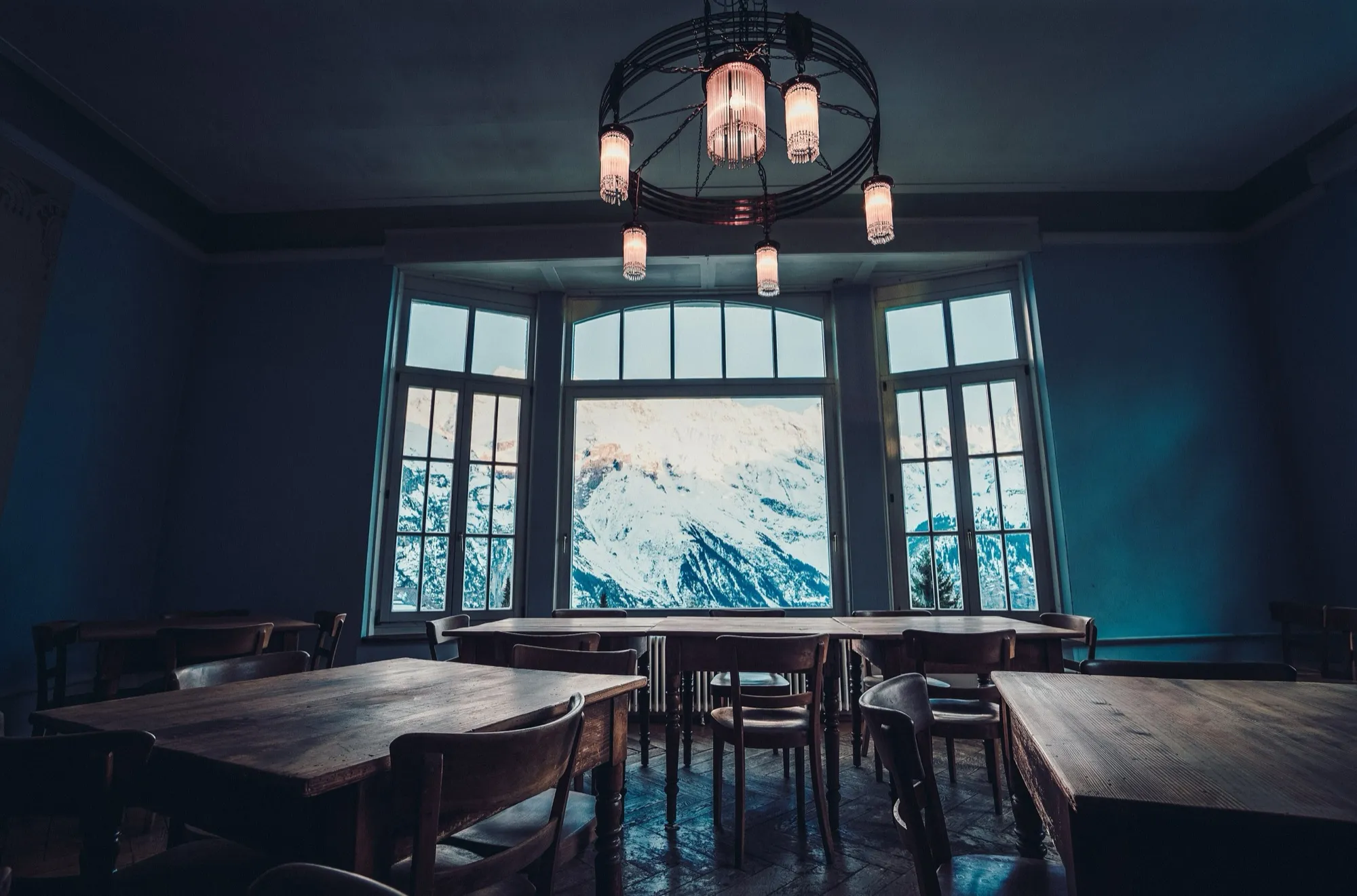 Comedor vacío de un hotel de montaña con grandes ventanales